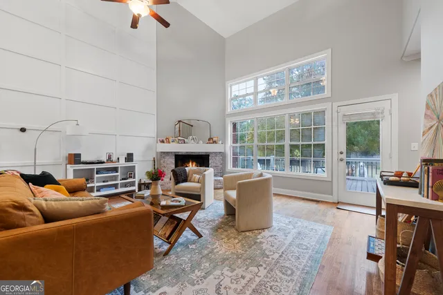 a living room with furniture a fireplace and a floor to ceiling window