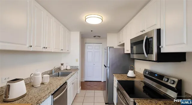 a kitchen with granite countertop a stove and a refrigerator