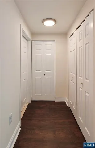an empty room with wooden floor and closet area