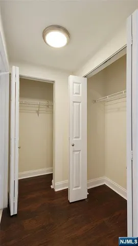 an empty room with wooden floor and closet