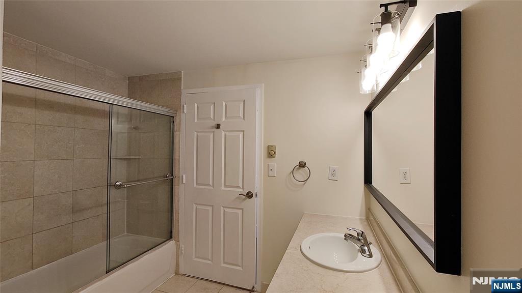 100 Old Palisade Road, Unit 1711 Fort Lee, NJ 07024 - Photo 18 of 26 a bathroom with a sink and mirror with bathtub