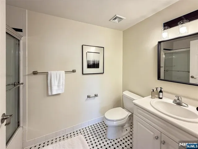 a bathroom with a toilet a sink a mirror and vanity