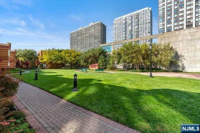 a garden with tall buildings in the background