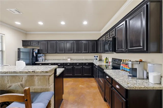 a kitchen with stainless steel appliances granite countertop sink stove top oven and cabinets