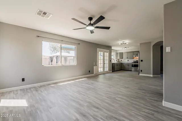 a view of empty room with wooden floor and window