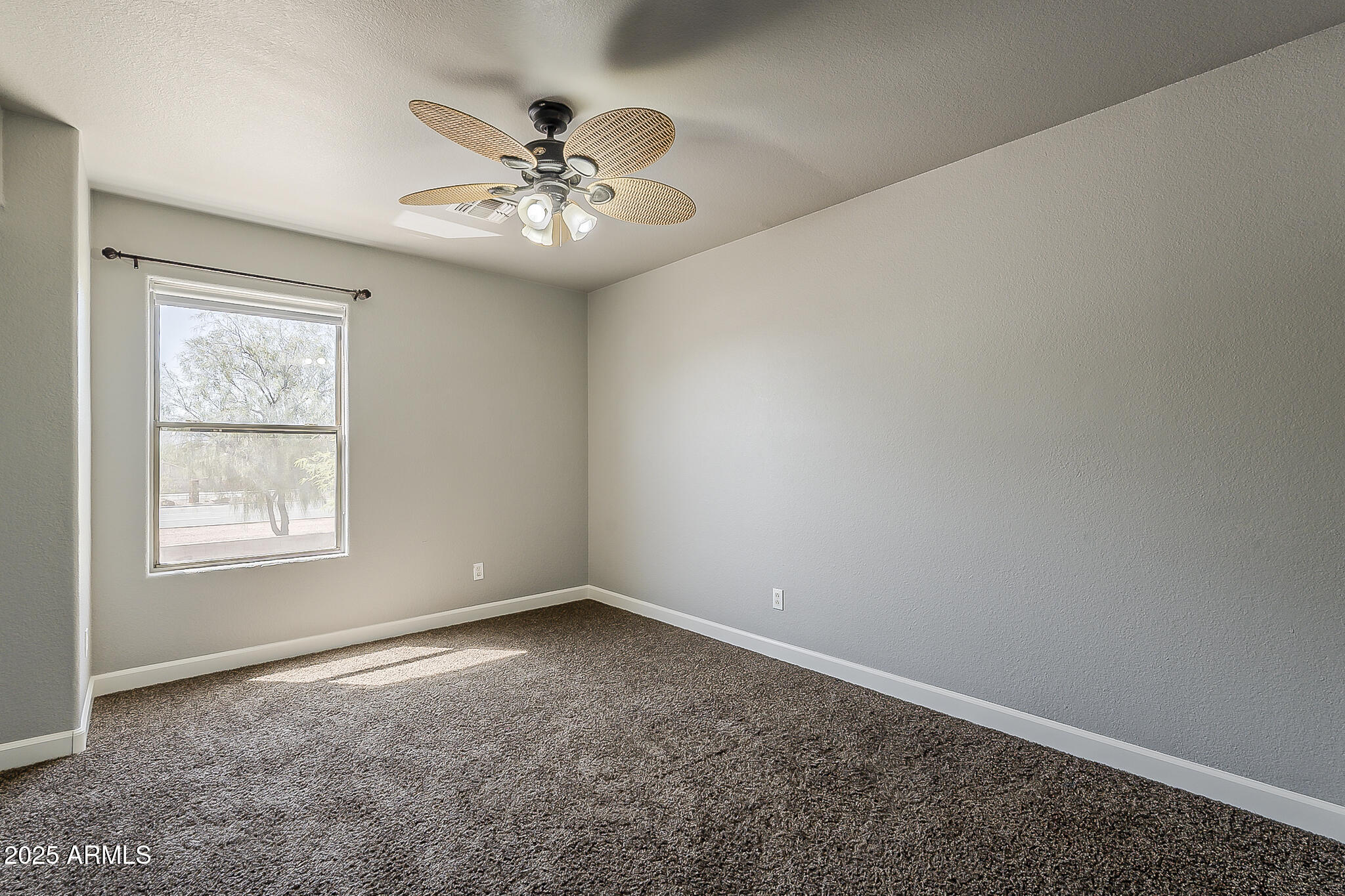 21928 North Braden Road Maricopa, AZ 85138 - Photo 31 of 58 an empty room with a chandelier fan and windows