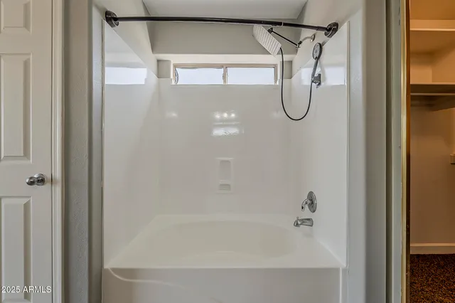 a backyard of a house with table and chairs under an umbrella