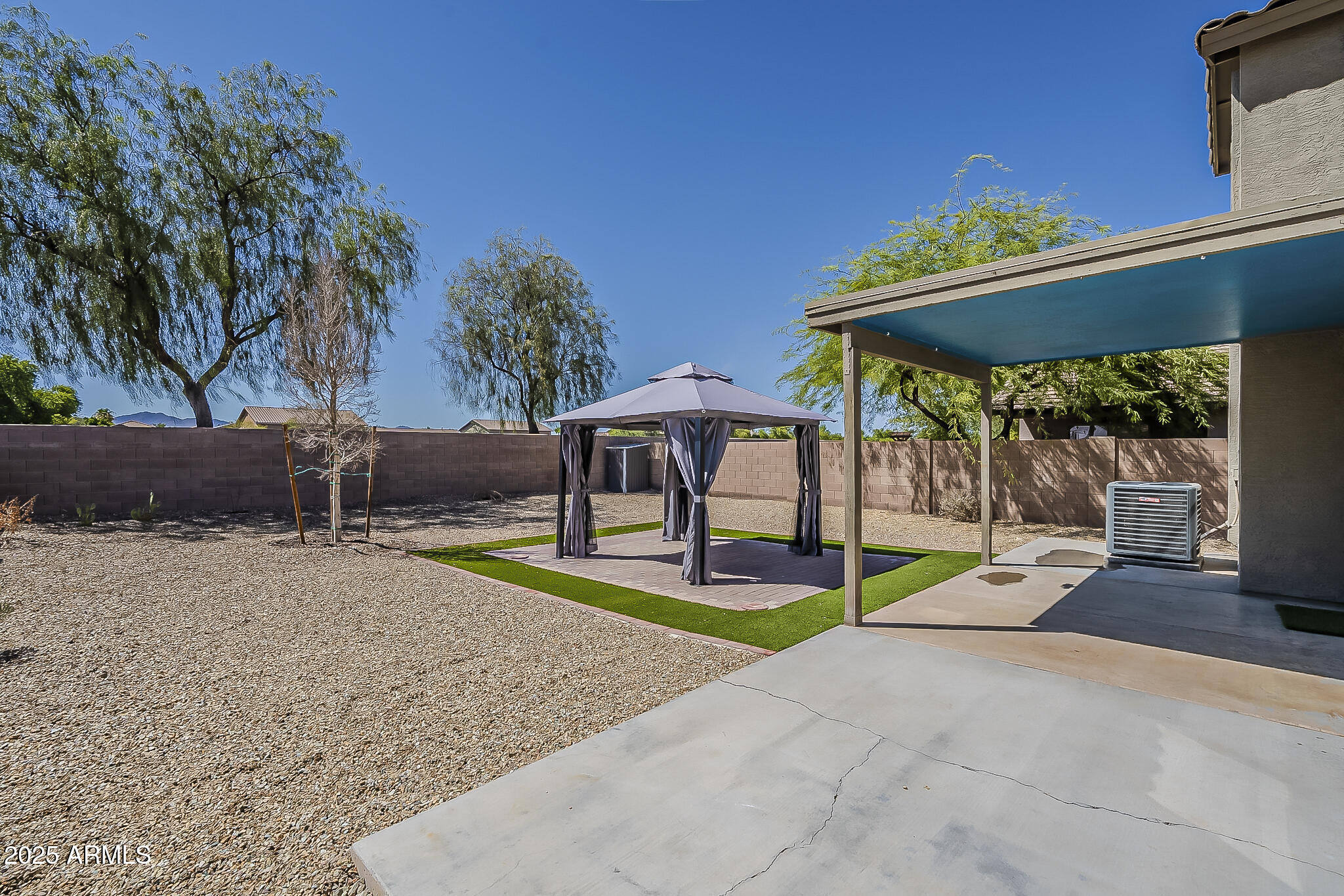 21928 North Braden Road Maricopa, AZ 85138 - Photo 53 of 58 a backyard of a house with table and chairs under an umbrella