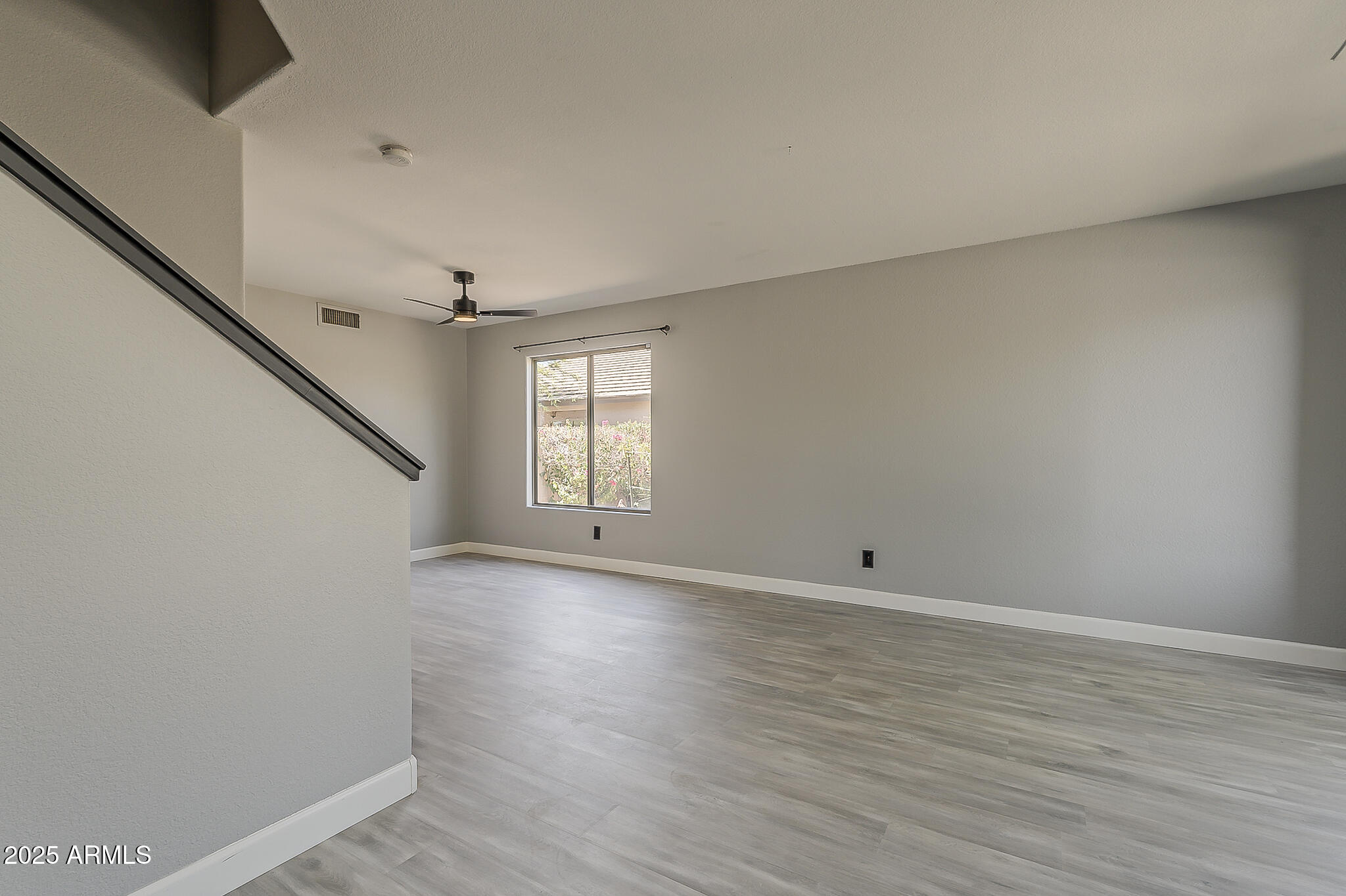 21928 North Braden Road Maricopa, AZ 85138 - Photo 6 of 58 a view of an empty room with wooden floor and a window