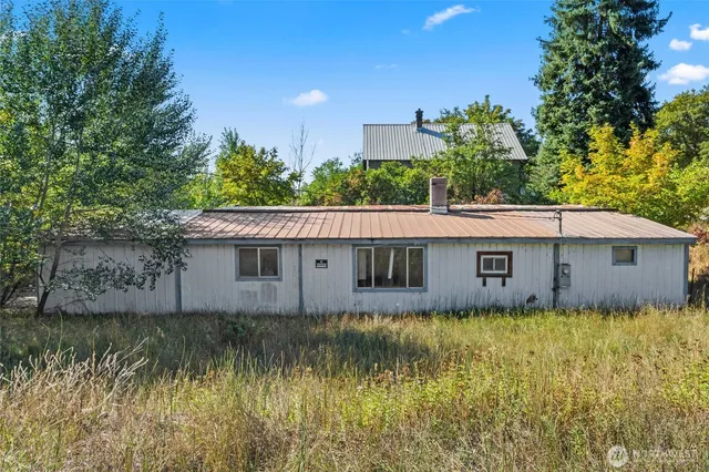 a backyard of a house with large trees and a yard
