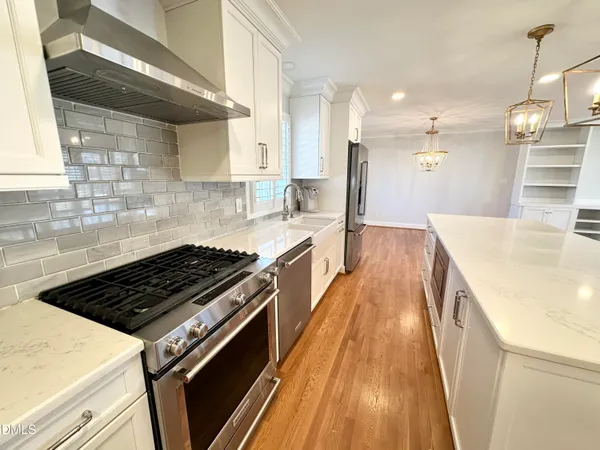 a kitchen with granite countertop a stove and a wooden floors