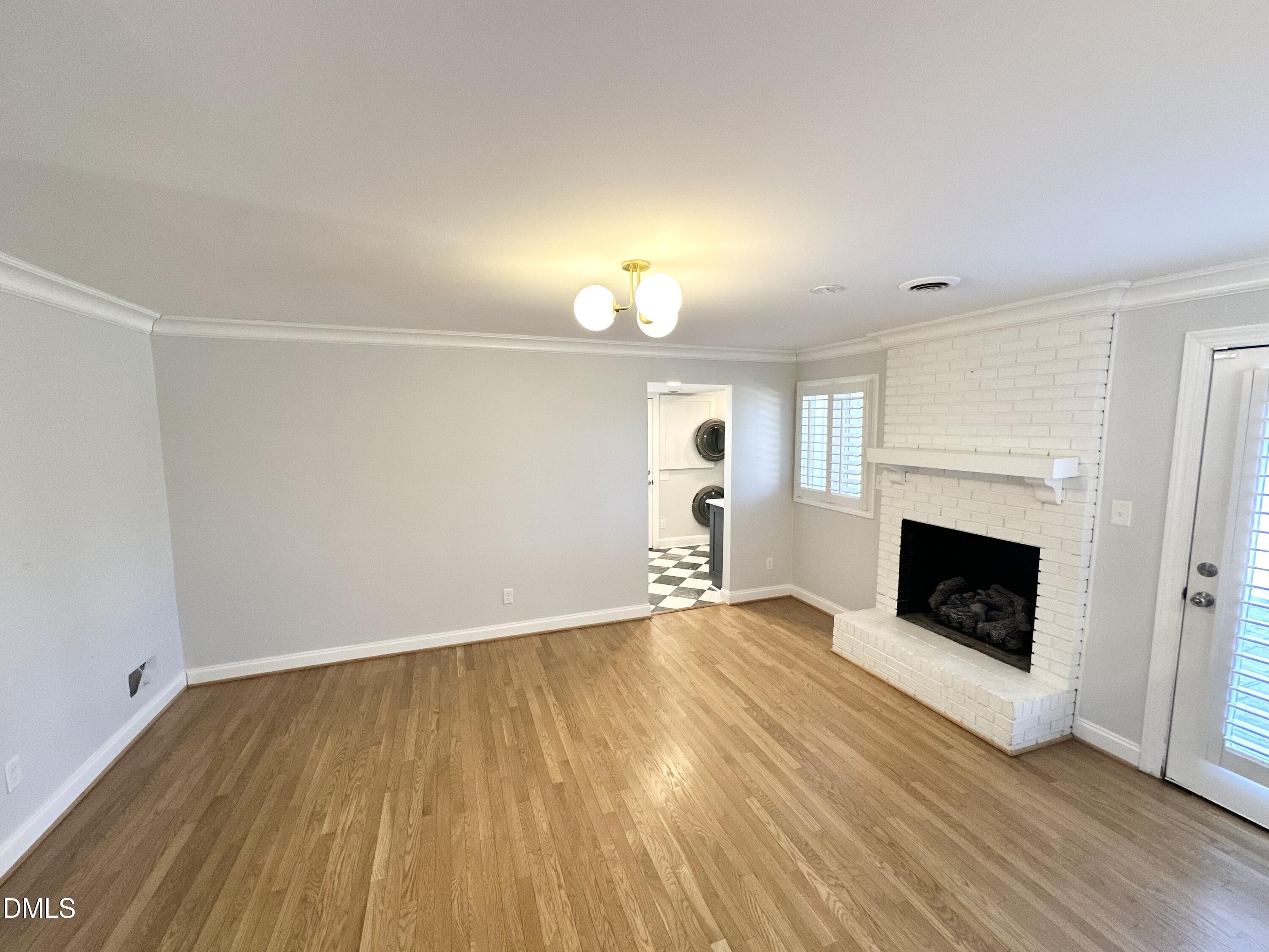 4512 Drexel Drive Raleigh, NC 27609 - Photo 12 of 36 an empty room with wooden floor fireplace and windows