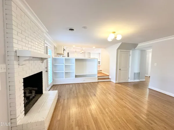 a view of a livingroom with a fireplace and wooden floor