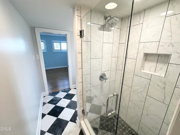 a bathroom with a glass door shower and a sink