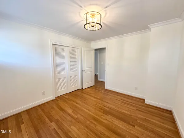 a view of empty room with wooden floor