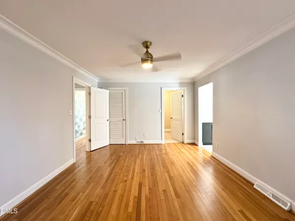 a view of a room with wooden floor and ceiling fan