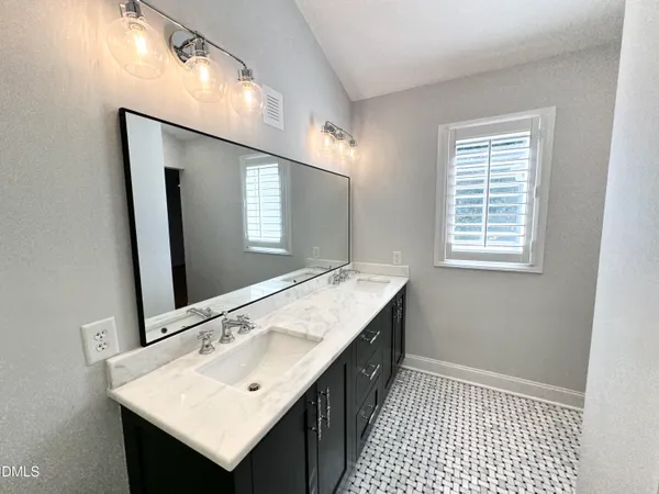 a bathroom with a sink a mirror and wooden floor