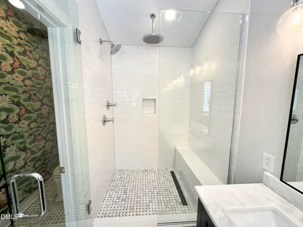 a bathroom with a sink a toilet a shower and a mirror