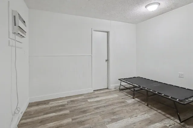 a room with a bench and white wooden floor