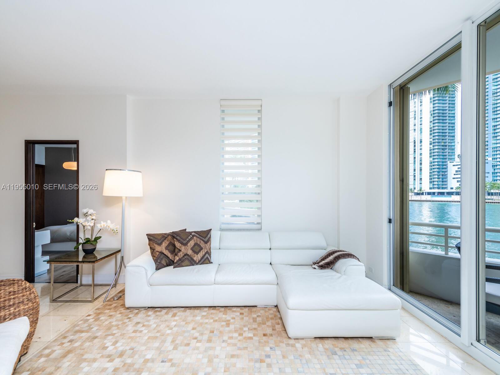888 Brickell Key Drive, Unit 210 Miami, FL 33131 - Photo 21 of 84 a living room with furniture and a lamp