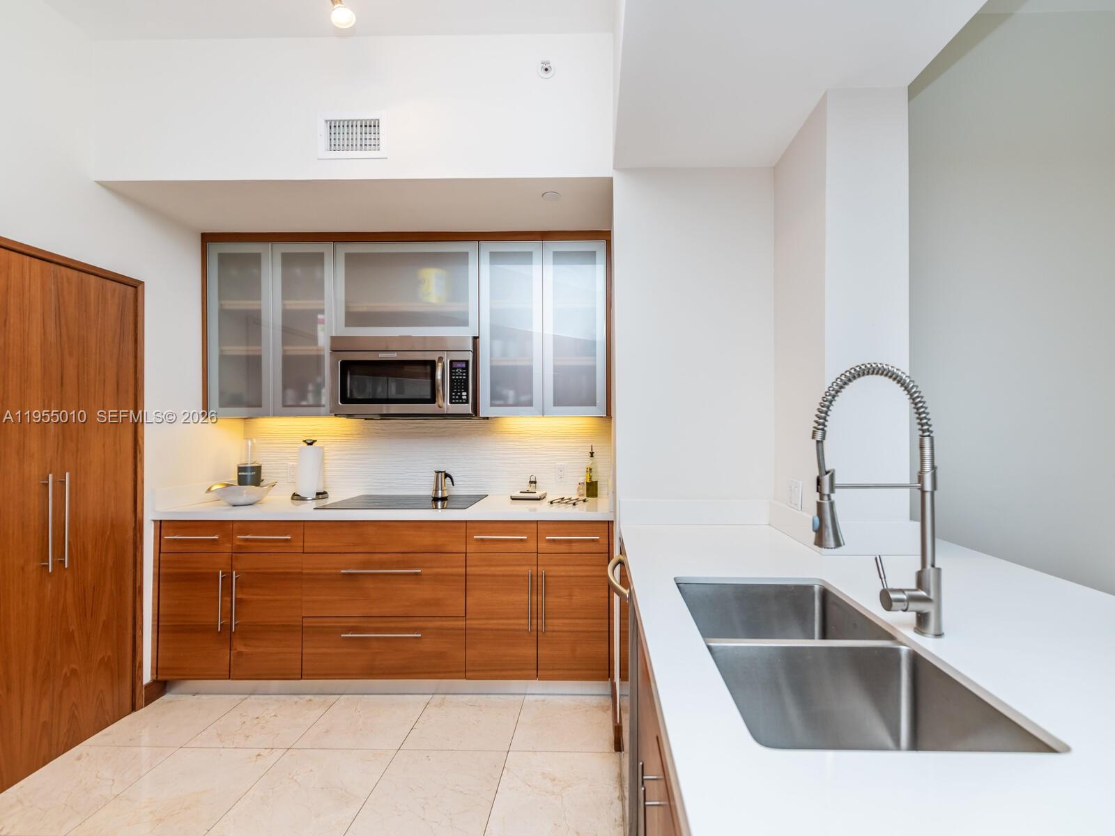 888 Brickell Key Drive, Unit 210 Miami, FL 33131 - Photo 6 of 84 a kitchen with a sink and a refrigerator