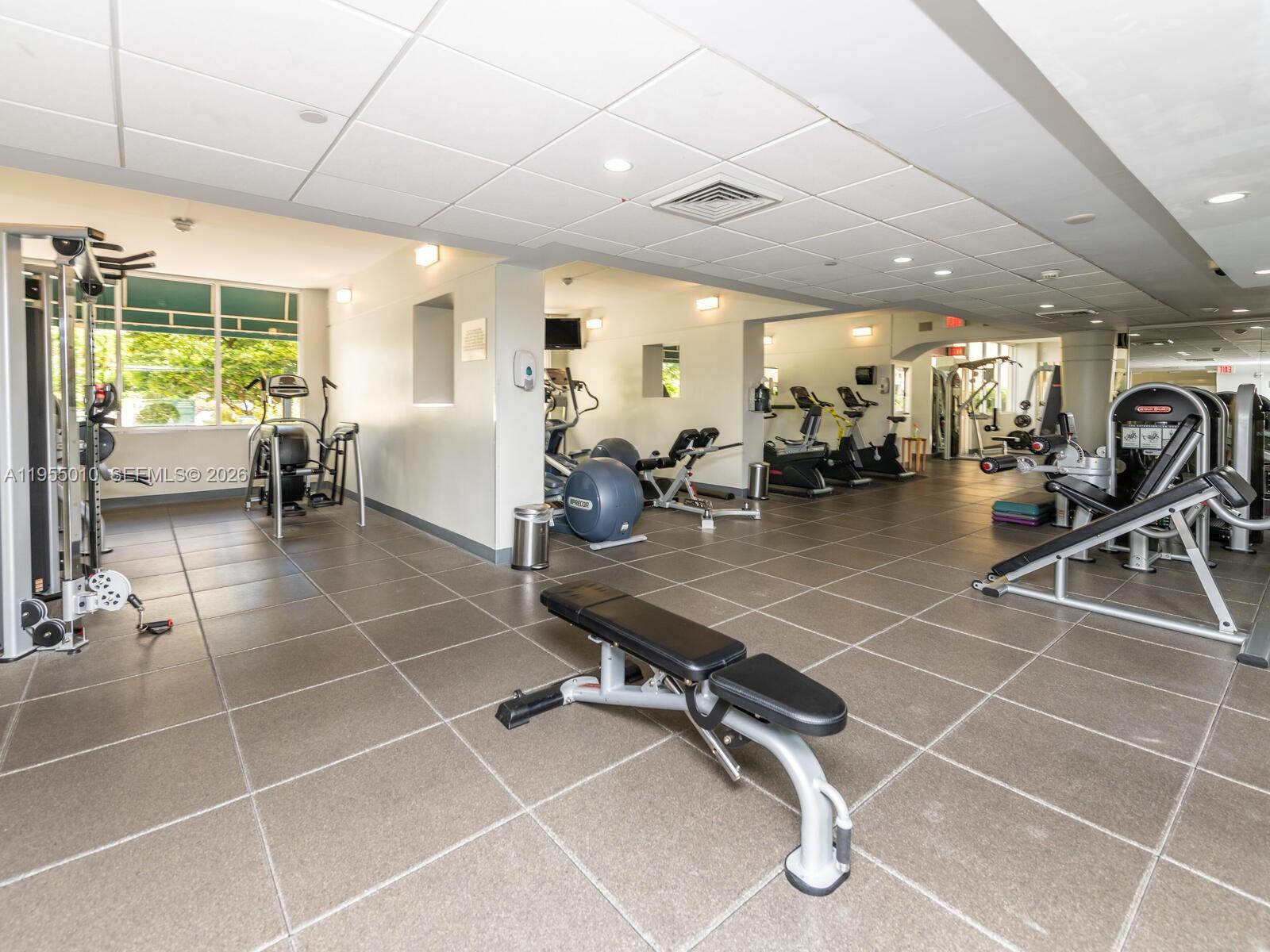 888 Brickell Key Drive, Unit 210 Miami, FL 33131 - Photo 62 of 84 a room with gym equipment and lots of tables