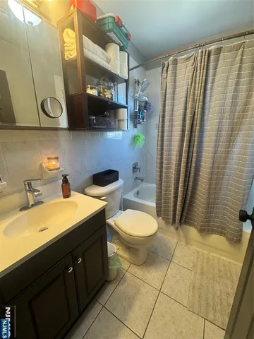 a bathroom with a sink a toilet and shower curtain