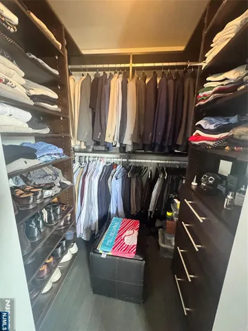 a view of walk in closet with clothes and shoes