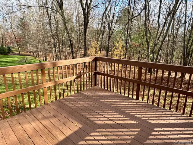 a view of a wooden balcony with trees