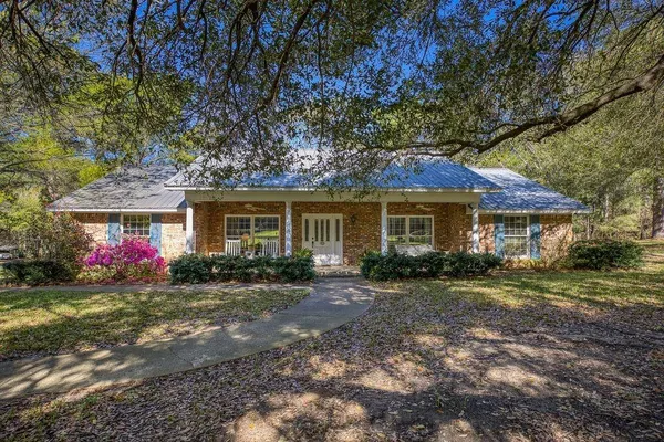 a front view of a house with a yard and trees