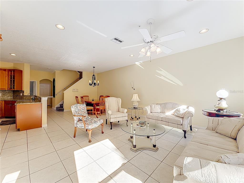 11117 Kapok Grand Circle Madeira Beach, FL 33708 - Photo 12 of 62 a living room with furniture and a chandelier