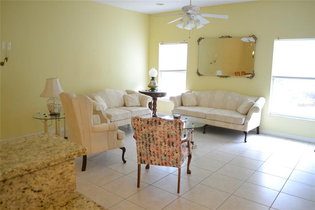 11117 Kapok Grand Circle Madeira Beach, FL 33708 - Photo 14 of 62 a living room with furniture and a chandelier