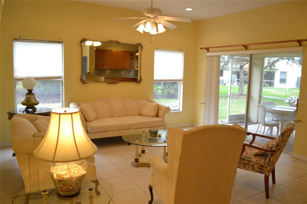 11117 Kapok Grand Circle Madeira Beach, FL 33708 - Photo 16 of 62 a living room with a couch and chandelier