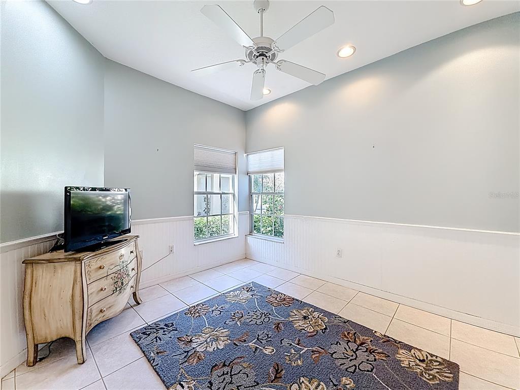 11117 Kapok Grand Circle Madeira Beach, FL 33708 - Photo 23 of 62 a living room with furniture and a flat screen tv