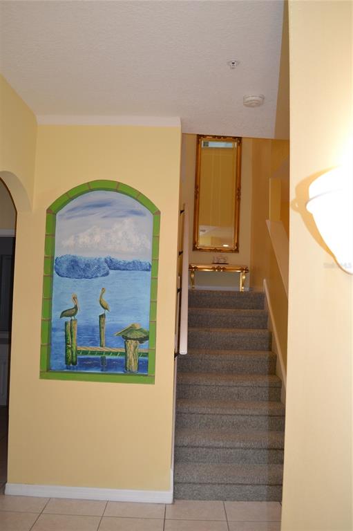 11117 Kapok Grand Circle Madeira Beach, FL 33708 - Photo 26 of 62 a view of a hallway with wooden floor and a large mirror