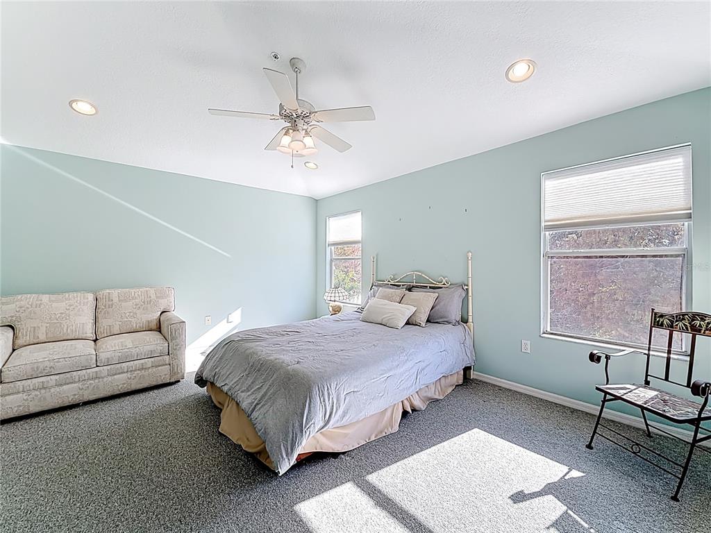 11117 Kapok Grand Circle Madeira Beach, FL 33708 - Photo 29 of 62 a bedroom with a bed a couch and a window