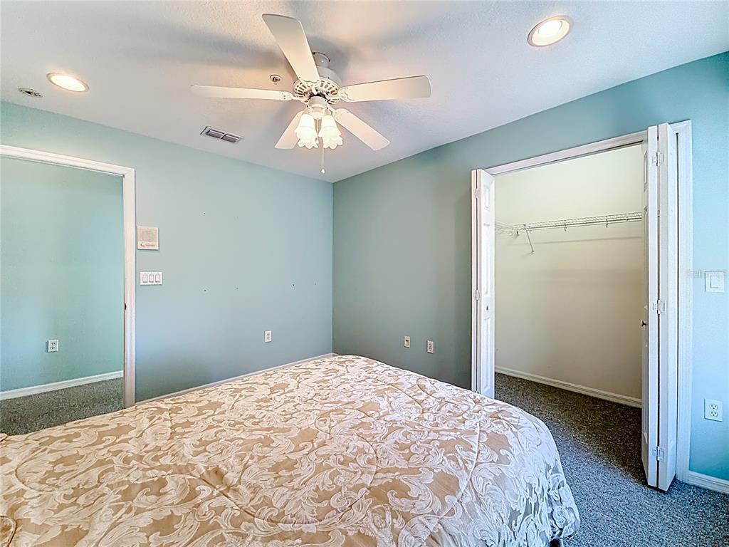 11117 Kapok Grand Circle Madeira Beach, FL 33708 - Photo 35 of 62 a bedroom with a large bed and a chandelier