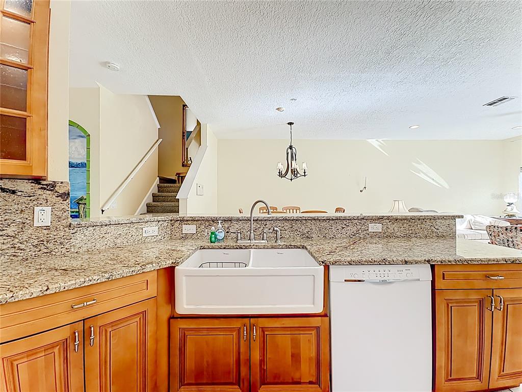 11117 Kapok Grand Circle Madeira Beach, FL 33708 - Photo 5 of 62 a kitchen with stainless steel appliances granite countertop a sink and cabinets with wooden floor