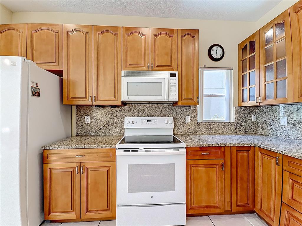 11117 Kapok Grand Circle Madeira Beach, FL 33708 - Photo 8 of 62 a kitchen with granite countertop cabinets stainless steel appliances and a counter space