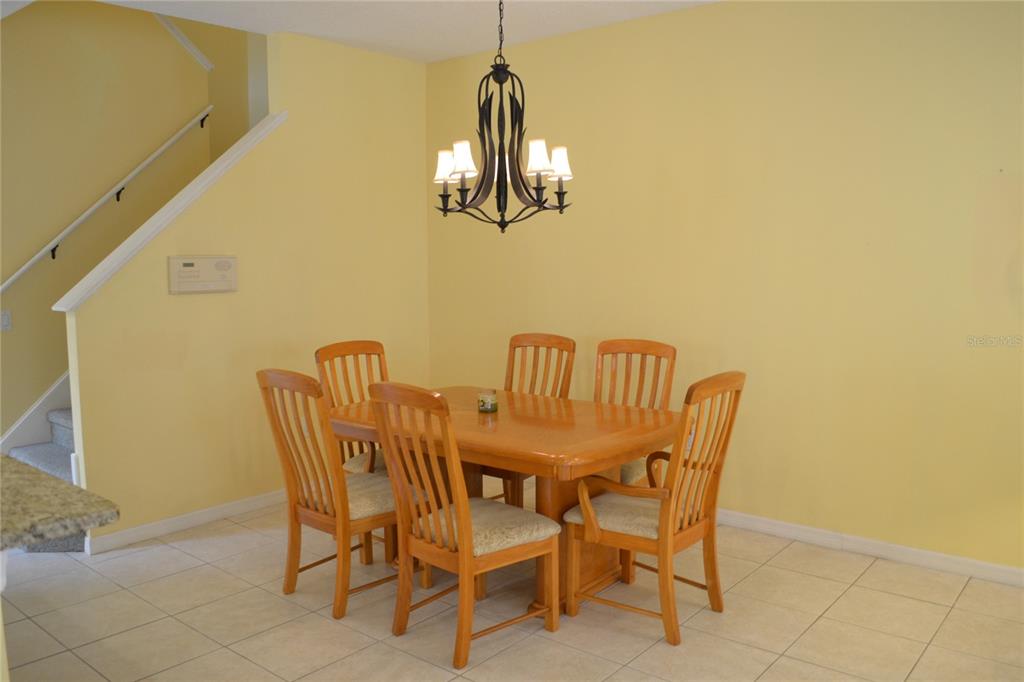 11117 Kapok Grand Circle Madeira Beach, FL 33708 - Photo 10 of 62 a dining room with furniture and chandelier