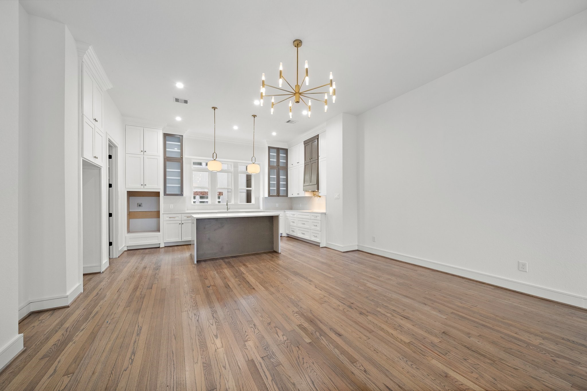 1013 East 28th Street Houston, TX 77009 - Photo 11 of 38 a large kitchen with a wooden floor and stainless steel appliances