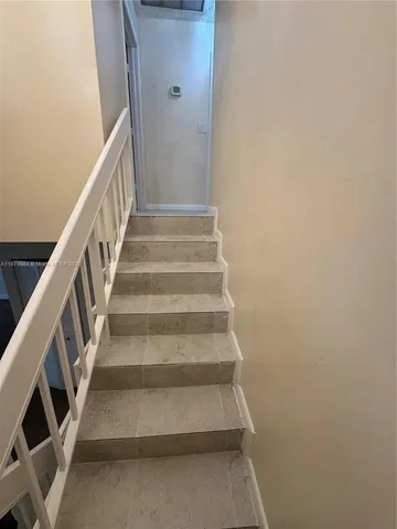 a view of staircase with lots of frames on wall