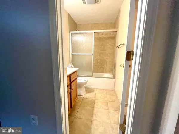 a bathroom with a glass shower door and a window