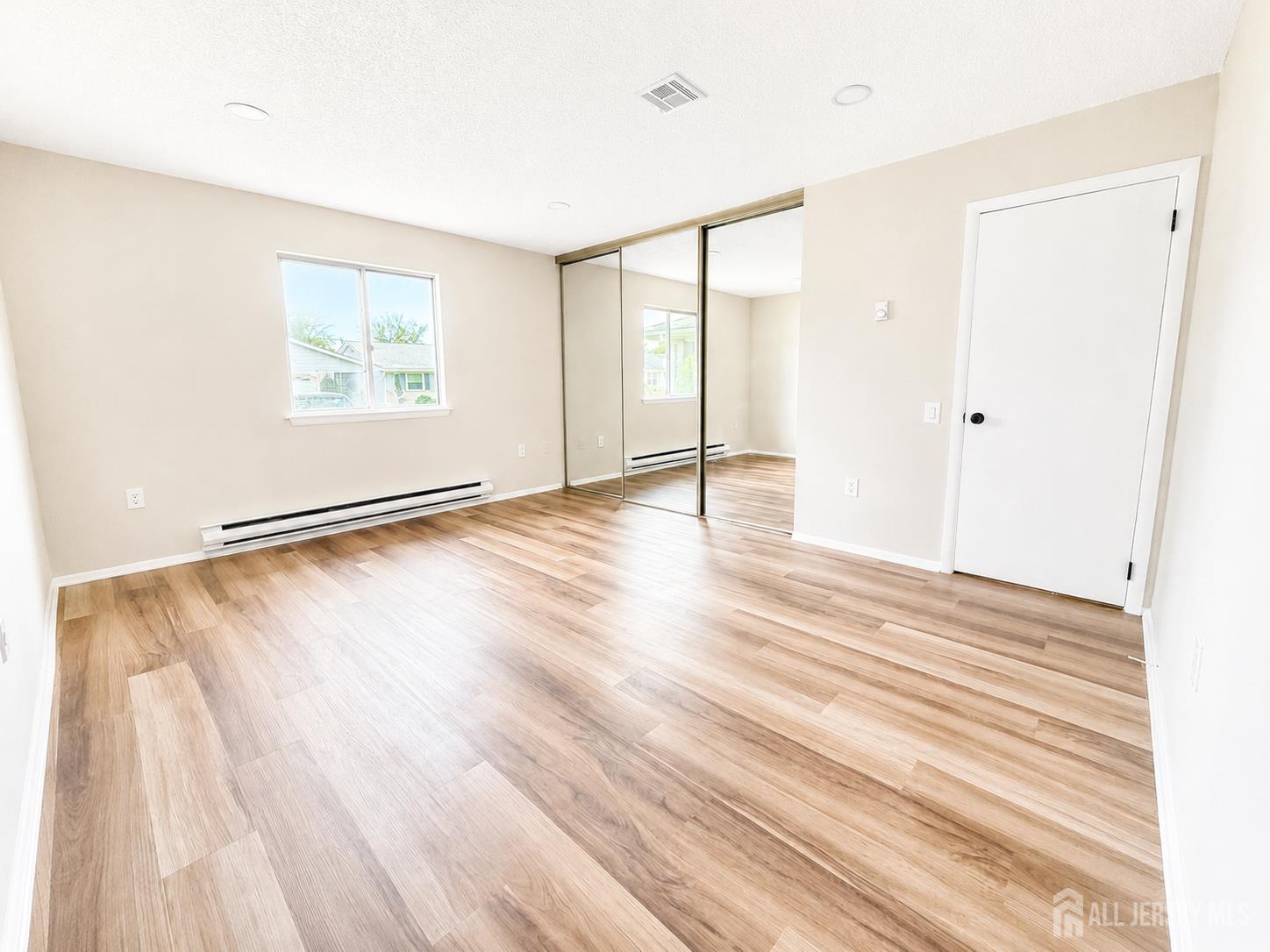 621 A Deal Road Monroe Township, NJ 08831 - Photo 18 of 27 a view of an empty room with wooden floor and a window