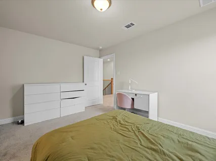 a bedroom with a bed and a desk