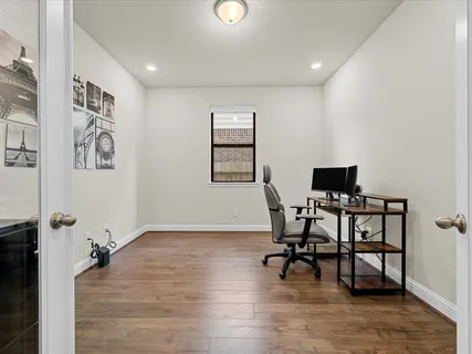 a view of a workspace with furniture and a window