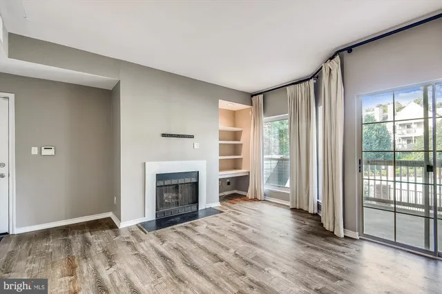wooden floor fireplace and windows in an empty room