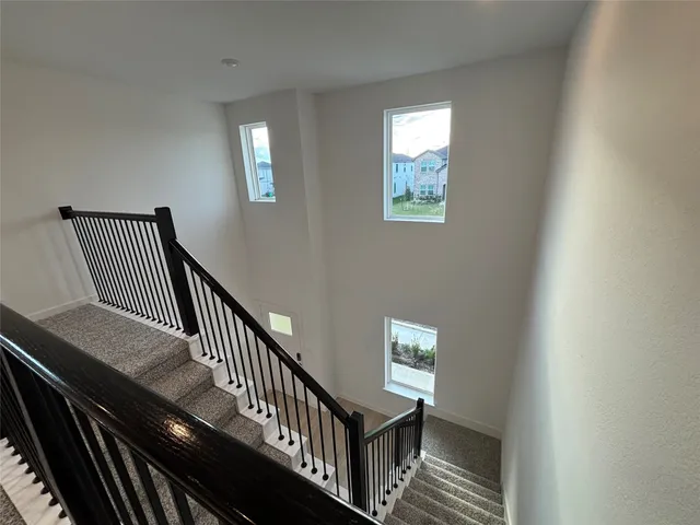 a view of staircase with railing and a window