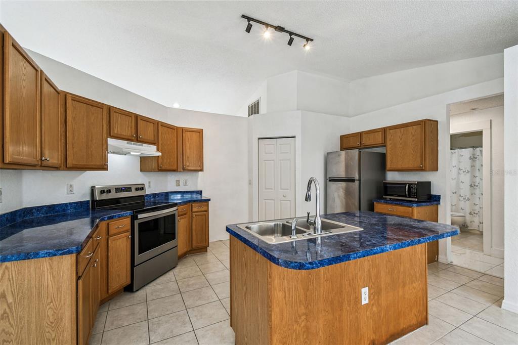 2222 Champlain Avenue Spring Hill, FL 34609 - Photo 27 of 74 a kitchen with stainless steel appliances granite countertop a sink stove and refrigerator