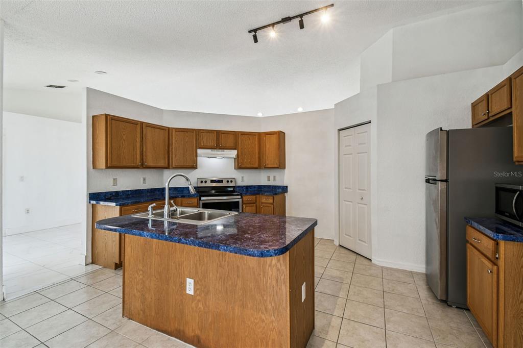 2222 Champlain Avenue Spring Hill, FL 34609 - Photo 29 of 74 a kitchen with kitchen island granite countertop a sink stove and refrigerator